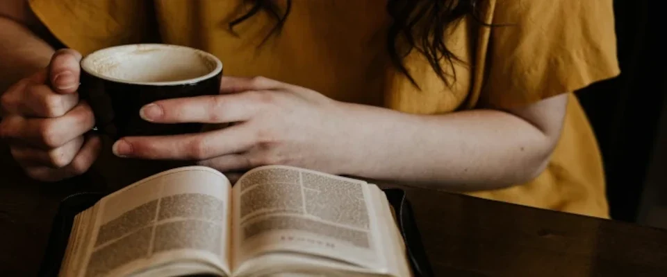 woman drinking coffee while reading