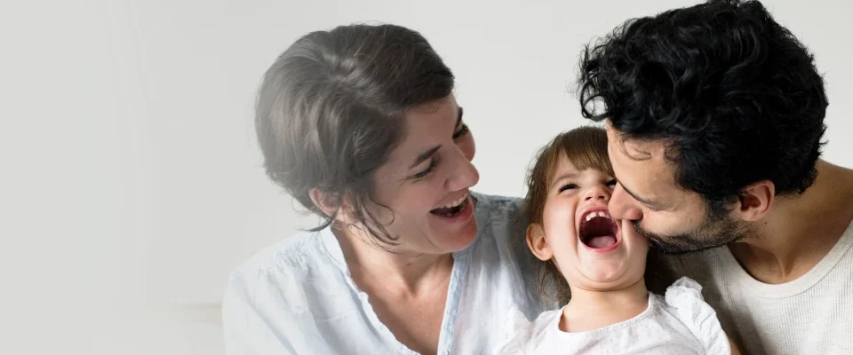 happy parents laughing together with daughter