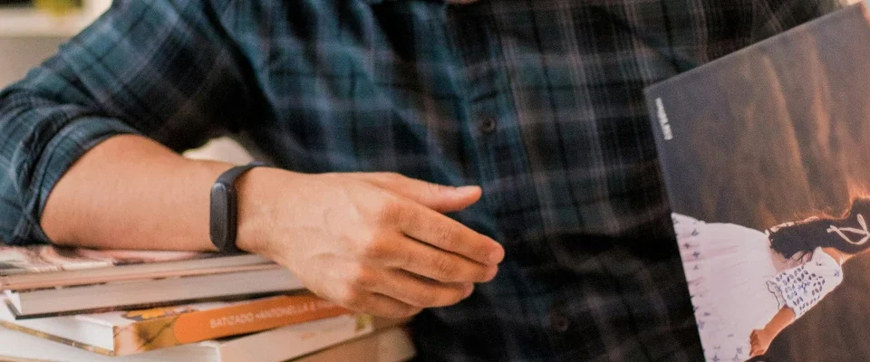 man holding a book while leaning on books