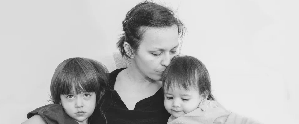 woman holding two child in her arms