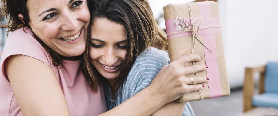 women with gift hugging sofa