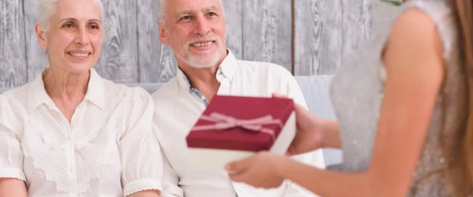 Grandchild giving gift to her grandparents