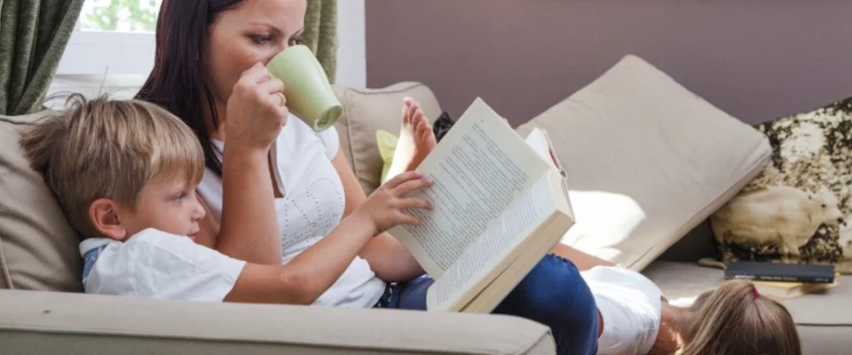 Family relaxing reading books sitting on couch