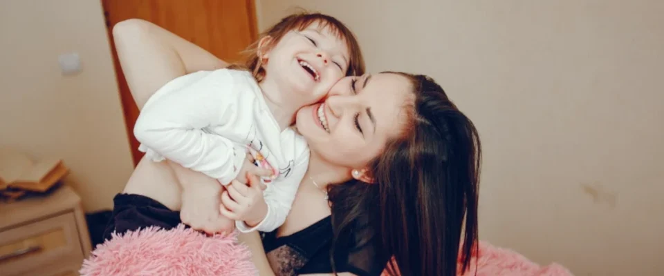 Mother with daughter sitting on a bed