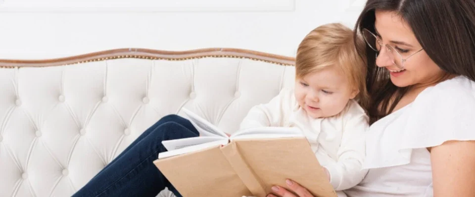 Woman reading with baby on sofa